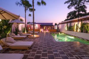 a patio with chairs and a pool in a house at El Barrio Boutique Hotel & Bar in Canggu