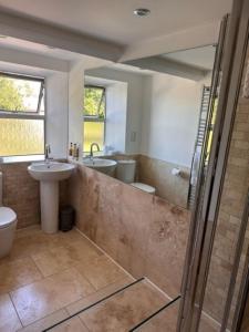 a bathroom with a sink and two toilets and a shower at Walltree House in Brackley