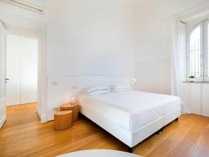 a white bedroom with a large white bed and wooden floors at Zash Country Boutique hotel & SPA in Giarre