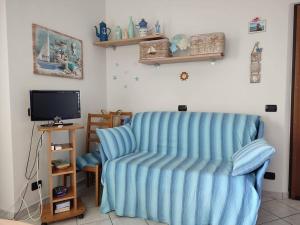 a living room with a blue chair and a television at Appartamento ITACA - CITRA 08065-LT-0722 in Ventimiglia