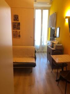 een slaapkamer met een bed, een bureau en een tafel bij Little Studio in Rue Biscarra in Nice