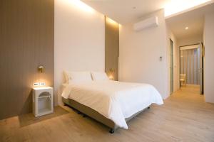 - une chambre avec un grand lit blanc dans l'établissement Nest in Ali Homestay, à Zhongpu