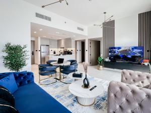 a living room with a blue couch and a tv at Trophy - Luxury Casa Cielo Suites in Dubai