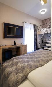 a bedroom with a bed and a desk and a television at ART Hotel in Sibiu