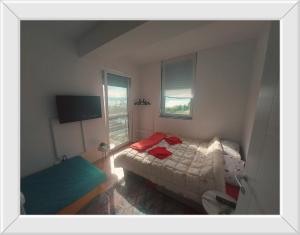 ein kleines Schlafzimmer mit einem Bett und einem Fenster in der Unterkunft APARTMENT ANA v-Peshtani in Ohrid