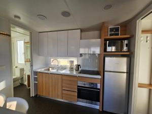 a kitchen with white cabinets and a stainless steel refrigerator at Villa Björkhagen in Jönköping