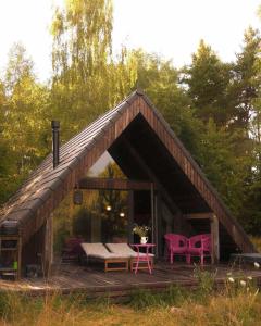 einem Pavillon mit zwei Stühlen und einem Tisch auf einer Terrasse in der Unterkunft Aušrinės in Liškiava