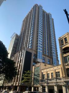 広州市にあるWAIFIDEN service Apartment Min Jian Fianance Branchの車が目の前に停まった大きな高層ビル