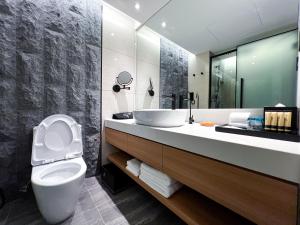 a bathroom with a white toilet and a sink at Hotel Royal Signature in Kuala Lumpur
