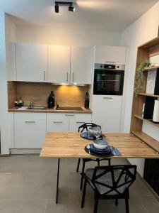 uma cozinha com armários brancos e uma mesa de madeira em BnB Open Apartments Pader-City em Paderborn
