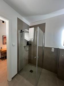 uma casa de banho com um chuveiro e uma cruz na parede em BnB Open Apartments Pader-City em Paderborn