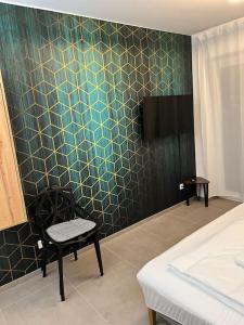um quarto com uma cadeira e uma parede em azulejo em BnB Open Apartments Pader-City em Paderborn