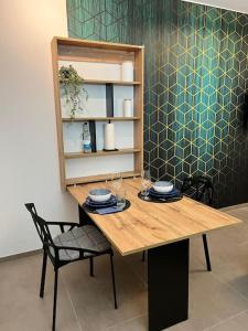 uma mesa de madeira com dois pratos e uma cadeira em BnB Open Apartments Pader-City em Paderborn