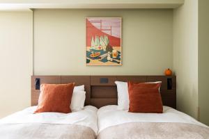 two beds sitting next to each other in a bedroom at Section L Ueno-Hirokoji in Tokyo