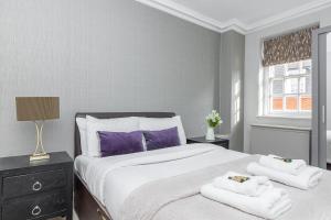 a bedroom with a large bed with towels on it at Exceptional 3BDR flat in Mayfair in London