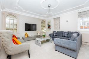 a living room with a couch and a tv at Exceptional 3BDR flat in Mayfair in London