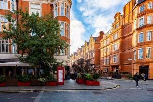 a city street with buildings and a red phone booth at Exceptional 3BDR flat in Mayfair in London