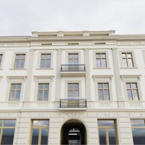 un grande edificio bianco con finestre e balcone di Hotel Pietryna a Łódź