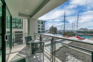 a balcony with chairs and a view of a marina at Fabulous Corner Apartment w/ Dazzling Harbour View in Auckland