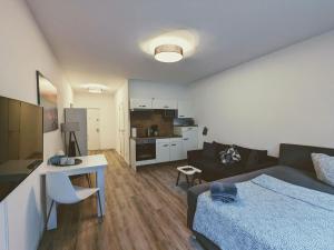 - une chambre avec un lit et un salon dans l'établissement Apartmenthaus am Park, à Wilhelmshaven