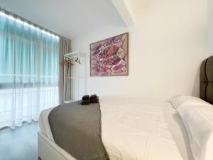 een witte slaapkamer met een bed en een raam bij Cosy Montroig Sitges in Sitges +8 foto's