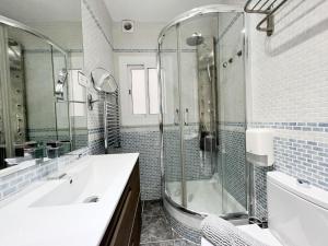 een badkamer met een bad, een wastafel en een douche bij Cosy Montroig Sitges in Sitges