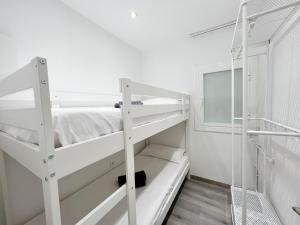 een kamer met twee stapelbedden en een raam bij Cosy Montroig Sitges in Sitges