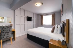 una camera d'albergo con letto e TV di Ye Olde Griffin a April