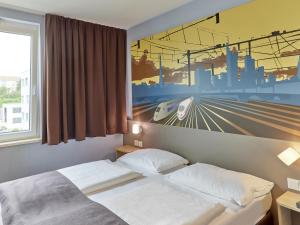Schlafzimmer mit einem Himmelbett an der Wand in der Unterkunft B&B Hotel Saarbrücken-Hbf in Saarbrücken