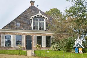 una casa de ladrillo con techo de gambrel en opdehoekvandestal en Workum