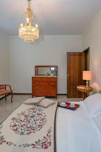 a bedroom with a bed and a dresser and a chandelier at Orsini: tre camere da letto, 2 bagni in Luco neʼ Marsi