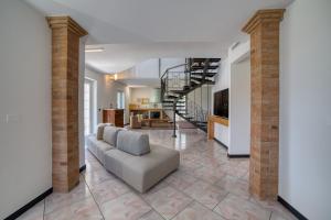 a living room with a couch and a spiral staircase at Villa Alba in Petacciato