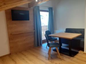 a room with a table and chairs and a television at Ferienhaus Haueis in Tumpen