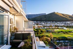 a balcony with a couch and a view of a city at The Apartment in Mouille Point in Cape Town