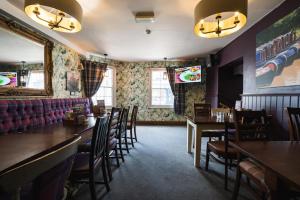 une salle à manger avec des tables et des chaises dans un restaurant dans l'établissement Ye Olde Griffin, à March