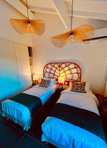 two beds in a room with two lamps at Only4view - Rooftop & spa Sainte-Anne in Sainte-Anne