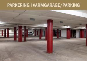 an empty parking lot with red columns in a parking garage at Hotel Bishops Arms Mora in Mora +43 photos