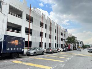 un parking avec des voitures garées devant un bâtiment dans l'établissement Swing & Pillows - KL Sri Petaling, à Kuala Lumpur