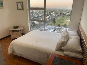 un letto in una camera con una grande finestra di B1001 Ocean View a Bloubergstrand