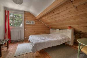 - une chambre avec un lit dans une pièce dotée de murs en bois dans l'établissement Escapade conviviale et familiale pres de la plage, à Pornichet