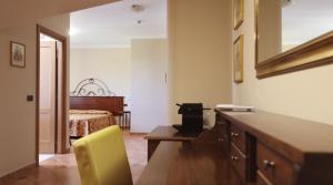 um quarto com uma cama e uma secretária com uma cadeira amarela em RESIDENCE VITTORIA em Acri