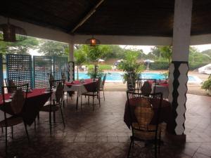 布松布拉的住宿－Hôtel Source Du Nil，一间带桌椅的餐厅和一个游泳池
