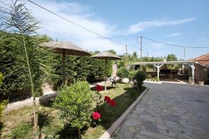 a garden with umbrellas and flowers in a yard at Villa Dionysia Two-bedroom House in Alikanas +3 photos