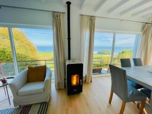 a living room with a fireplace and a table and chairs at Marina House in Pechón