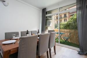uma sala de jantar com uma mesa de madeira e cadeiras em Canela Homes BARCELONA PADILLA em Barcelona