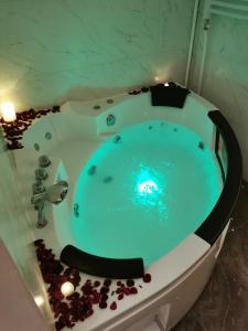 a bathroom with a blue tub with rocks around it at Princ Lux Spa with free parking in Novi Sad