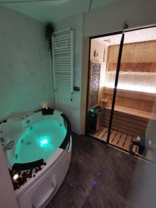 a bathroom with a jacuzzi tub next to a wooden deck at Princ Lux Spa with free parking in Novi Sad