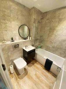 a bathroom with a sink and a toilet and a tub at Beautiful 1 Bed Flat near NEC with secure parking in Birmingham