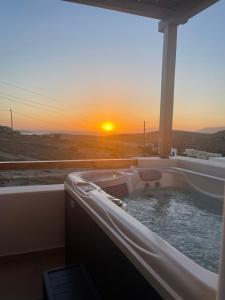 斯希努薩島的住宿－Sohoros Luxury Suites，享有日落美景的热水浴池