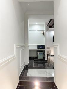 a kitchen with white walls and a black tile floor at Relais Parlamento in Rome